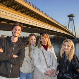 Young travelers exploring UFO Bridge landmark in Bratislava.