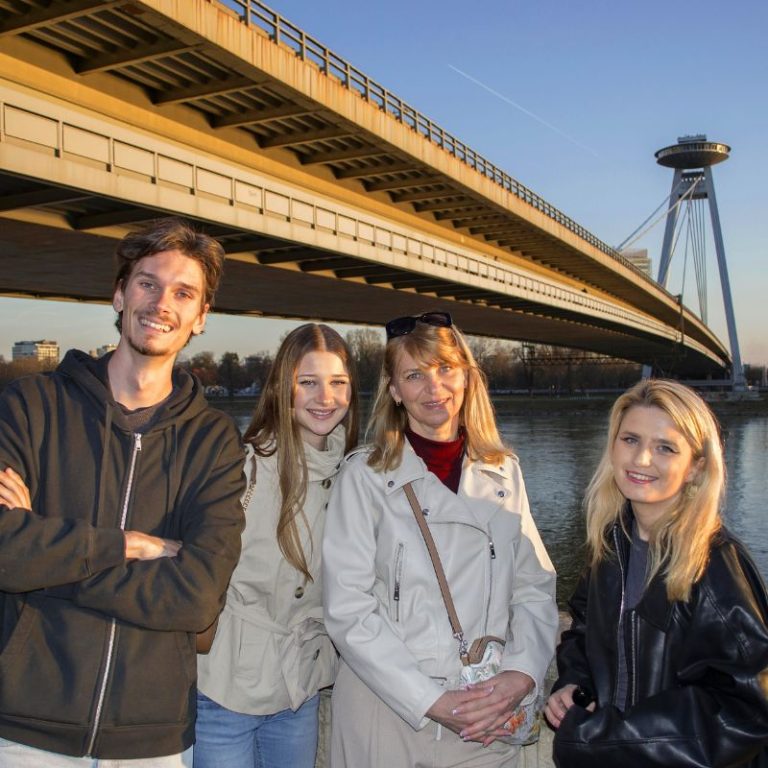 Young travelers exploring UFO Bridge landmark in Bratislava.
