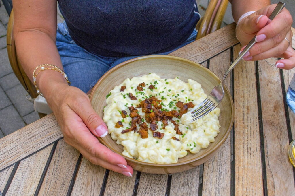 Bowl of potato dumplings with creamy cheese and crispy bacon