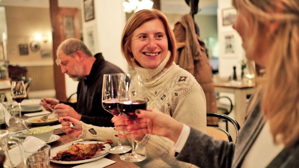 Tourists dining and drinking wine at a traditional restaurant in Bratislava.