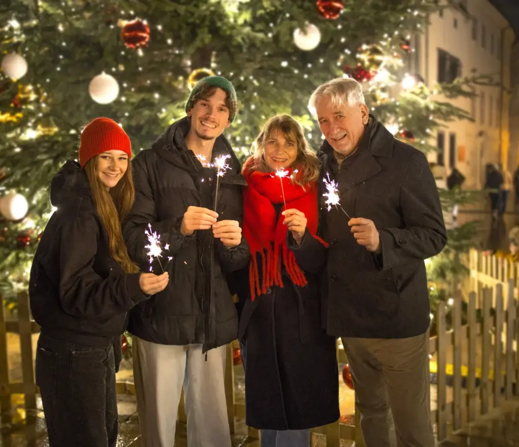 Happy tourists holding sparklers at the Bratislava Christmas Markets Food Tour during a festive evening food tour.