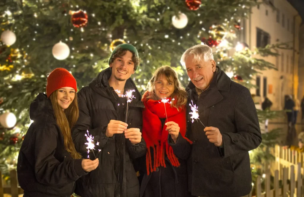 Smiling guests holding sparklers at the Bratislava Christmas markets
