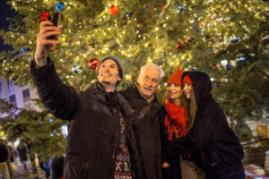 Guide Jakub taking a selfie with guests by the Christmas tree at the Bratislava Christmas market