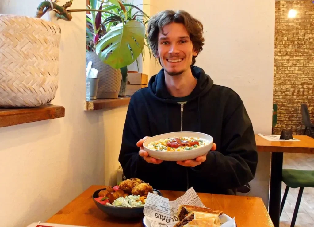 Local guide enjoying plant-based lunch during Bratislava vegan food tour.