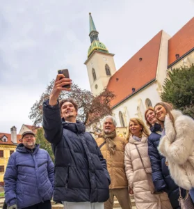 Tour group taking a selfie with guide Jakub in front of a church in Bratislava